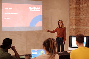 Young woman presenting on digital evolution concepts like AI and big data in a seminar. HD wallpaper