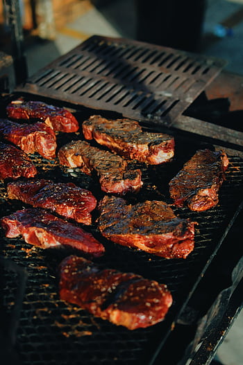 Sizzling steaks on a charcoal grill, perfect for a backyard BBQ. HD phone wallpaper