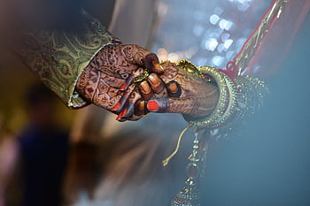 A beautiful capture of mehndi-decorated hands symbolizing love and tradition in a wedding ceremony. HD wallpaper