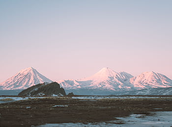 Experience the serene beauty of snow-capped mountains in Kamchatka at sunrise, captured in a tranquil winter setting. HD wallpaper
