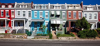 Vibrant row houses on a sunny street capturing urban architecture and charm. HD wallpaper