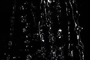 Detailed close-up of water droplets splashing on a dark background, creating a dramatic and abstract effect. HD wallpaper