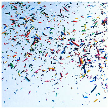 Vibrant multi-colored confetti scattered on a white surface creating an abstract and festive design. HD phone wallpaper