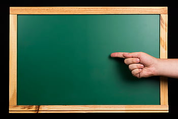 Green chalkboard framed in wood with a hand pointing, isolated on black. Ideal for educational themes. HD wallpaper