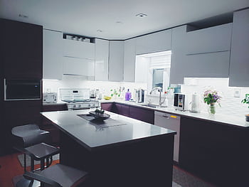 Contemporary kitchen interior with sleek white cabinets and island, perfect for a minimalist aesthetic. HD wallpaper