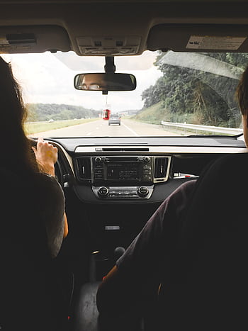 View from inside a car showing passengers looking out at an open highway, emphasizing travel and journey. HD phone wallpaper