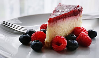 A tempting slice of cheesecake topped with berries, perfect for dessert lovers. HD wallpaper