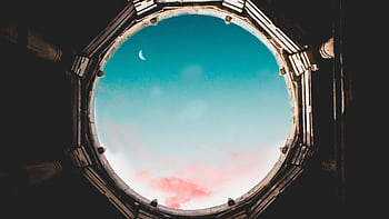 Majestic crescent moon visible through an ancient round oculus against a vibrant sky. HD wallpaper