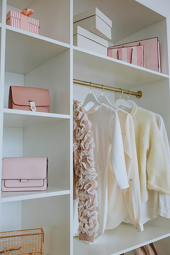 Stylish feminine wardrobe with clothes, bags, and gifts neatly organized on shelves. HD phone wallpaper