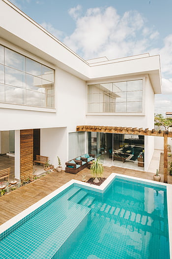 Contemporary villa featuring a sleek pool and minimalist design under a bright sky. HD phone wallpaper