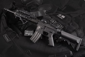 Detailed view of military rifles and tactical equipment, showcasing precision. HD wallpaper