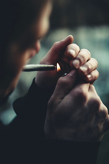 Close-up of a person lighting a cigarette with a lighter, focused on hands. HD phone wallpaper