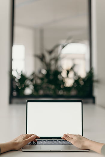 A minimalist workspace featuring an open laptop in a bright, serene indoor setting. HD phone wallpaper