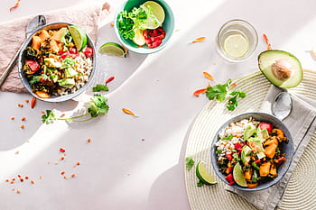 Top-down view of vibrant vegan bowls filled with fresh vegetables, perfect for a healthy meal. HD wallpaper