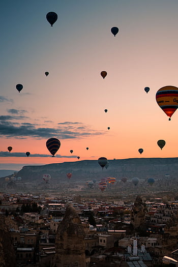A breathtaking view of colorful hot air balloons floating above Cappadocia's unique landscape during a tranquil sunrise. HD phone wallpaper
