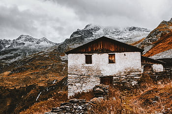 Scenic view of an abandoned cabin against snow-capped mountains in fall. HD wallpaper
