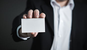 A man in a suit presenting a blank business card for corporate usage. HD wallpaper