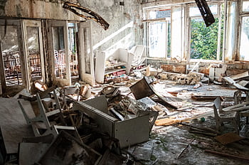 A desolate room filled with decayed furniture, debris, and broken windows, illustrating urban decay. HD wallpaper