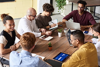 A group of professionals having a meeting in a modern office environment, fostering teamwork and brainstorming. HD wallpaper