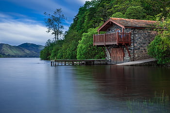 Charming lakefront cabin surrounded by lush greenery and serene waters, perfect for nature lovers. HD wallpaper