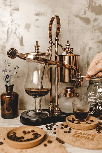 A vintage espresso maker brewing coffee cup in a cozy setting, highlighting timeless charm. HD phone wallpaper
