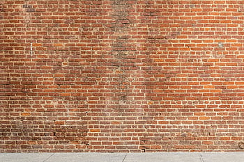 Detailed of a textured red brick wall with a concrete base, ideal for architectural and design backgrounds. HD wallpaper