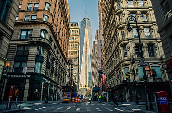 Street view of One World Trade Center in New York City surrounded by urban architecture and city life. HD wallpaper