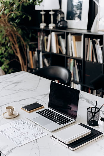 A modern minimalist workspace featuring a laptop, notebook, and coffee cup on a marble table. HD phone wallpaper