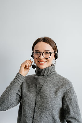 Friendly customer support woman smiling while wearing a headset in the office. HD phone wallpaper
