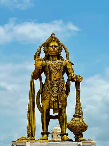 Golden Hanuman statue in Sarangpur, India, under a blue sky, symbolizing strength and devotion. HD phone wallpaper