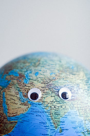 A whimsical globe adorned with googly eyes, symbolizing global awareness and humor. HD phone wallpaper