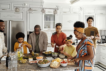 A happy family gathers in the kitchen to prepare a delicious meal together, fostering togetherness and joy. HD wallpaper