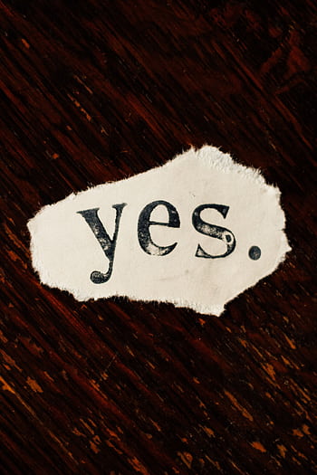 A rustic torn paper displaying the word 'yes' against a textured wooden background. HD phone wallpaper