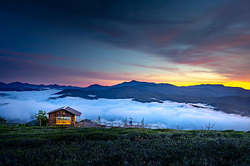 Peaceful sunrise view of a wooden cabin amidst the mountain mist in Đà Lạt. HD wallpaper