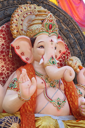 Close-up of a colorful, ornate Ganesha statue symbolizing Hinduism and Indian culture. HD phone wallpaper