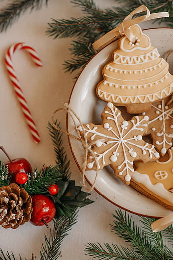 A cozy arrangement of gingerbread cookies and Christmas decorations, perfect for the holiday season. HD phone wallpaper