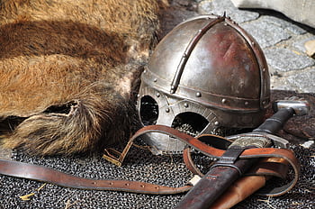 Close-up of medieval armor, helmet, and sword in a classic setting. HD wallpaper