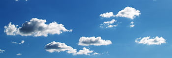 Peaceful blue sky filled with fluffy white clouds on a sunny day. HD wallpaper