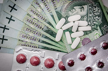 Polish 100 złoty notes with pills and blister packs, illustrating medical costs. HD wallpaper