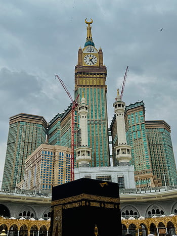 Kaaba and Abraj Al Bait under a cloudy sky in Makkah, Saudi Arabia, showcasing Islamic architecture. HD phone wallpaper