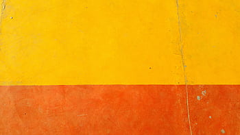 Close-up of a textured yellow and orange wall with rough surface HD wallpaper