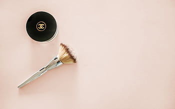 Sophisticated flatlay of a makeup brush and branded cosmetic jar on a pastel background. HD wallpaper