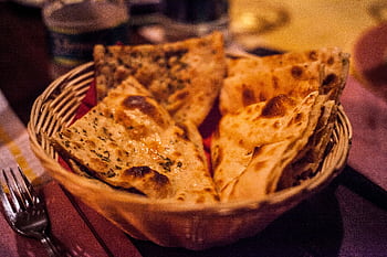 Close-up of traditional Indian flatbreads in a basket, perfect for a delicious meal. HD wallpaper