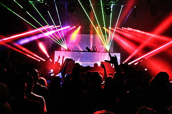 Energetic nightclub scene with laser lights and a lively crowd dancing to EDM music. HD wallpaper