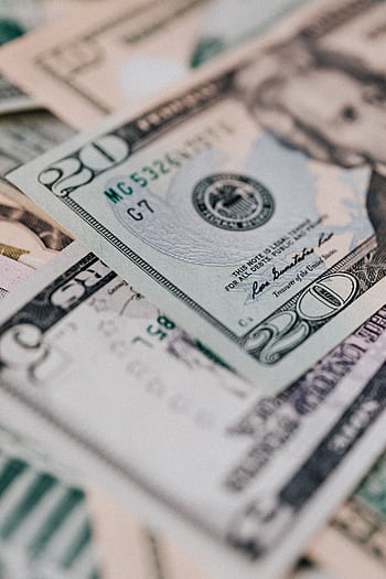 Detailed close-up of various US dollar banknotes scattered in an overlapping pattern. HD phone wallpaper