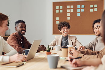 A diverse group of professionals collaborating during a brainstorming session in a modern office setting. HD wallpaper