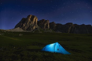 Camping under the starlit sky in the Dolomites, with a view of rugged cliffs in Italy. HD wallpaper