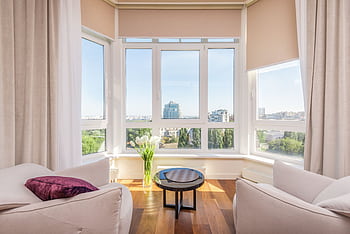 Spacious living room featuring panoramic windows and modern furnishings. HD wallpaper