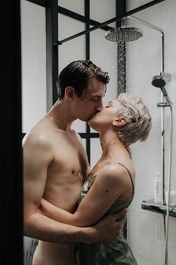 A romantic moment captured between a couple kissing passionately under a shower. HD phone wallpaper