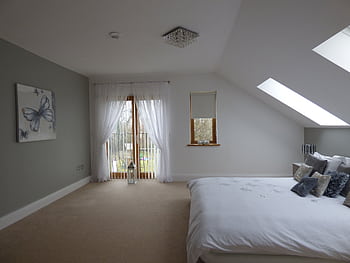 Explore a spacious modern bedroom with skylights, soft decor, and natural lighting. HD wallpaper